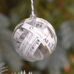 A clear Christmas ornament with the song, "O Come, All Ye Faithful" inside.