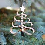 A Christmas tree ornament with ribbon, beads, and essential oils.